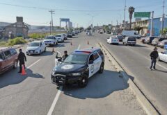 Checkpoint in action: Officers along the Tecate–Tijuana highway check cars for stolen vehicles and illegal goods—slowing traffic, speeding up justice.
