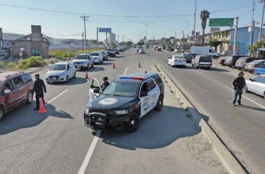 Checkpoint in action: Officers along the Tecate–Tijuana highway check cars for stolen vehicles and illegal goods—slowing traffic, speeding up justice.