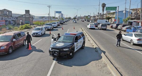 Checkpoint in action: Officers along the Tecate–Tijuana highway check cars for stolen vehicles and illegal goods—slowing traffic, speeding up justice.