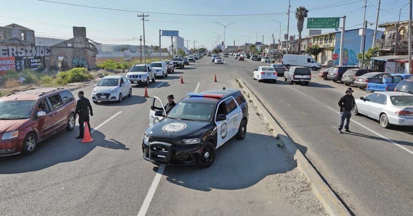 Checkpoint in action: Officers along the Tecate–Tijuana highway check cars for stolen vehicles and illegal goods—slowing traffic, speeding up justice.